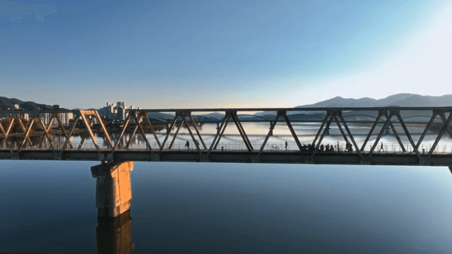 산과 고요한 호수 위의 긴 다리