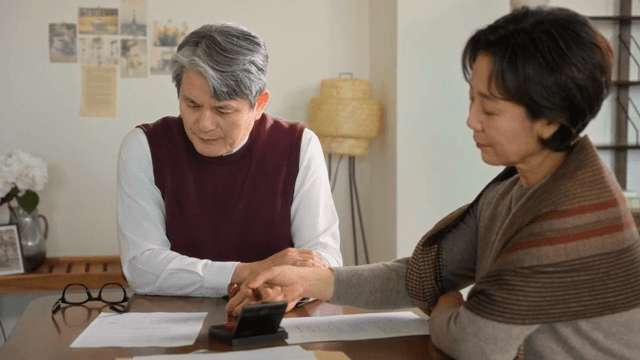 책상 위 서류를 읽고 도장을 찍는 여성