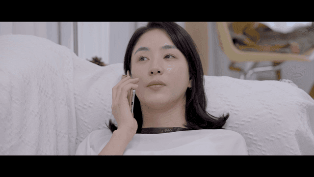 Woman lying on sofa making phone call