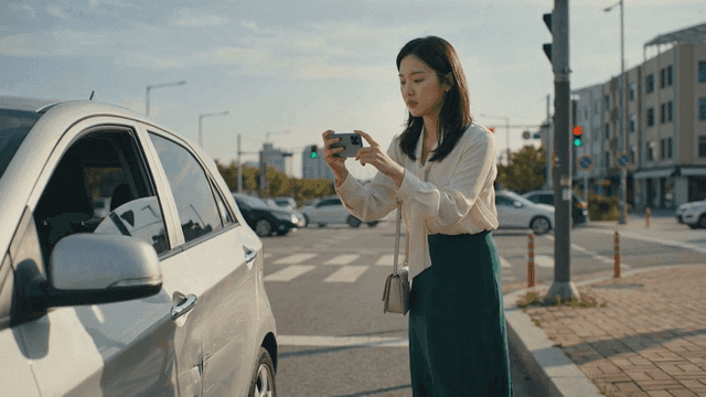 Woman taking photos of a damaged car