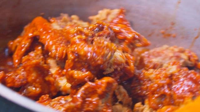매콤한 소스로 바삭한 치킨을 양념하는 모습