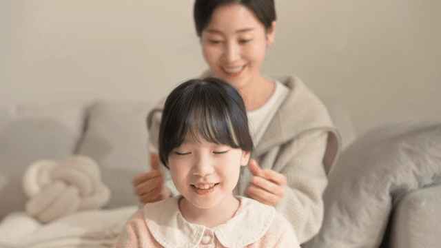 Mother braiding her daughter's hair