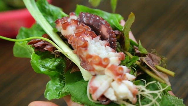 Parboiled octopus and lettuce wrap served with chili peppers