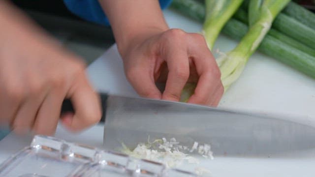 Cutting a green onion on a wooden board