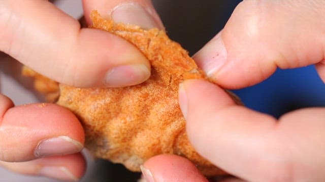 Hands breaking open a warm walnut cakes