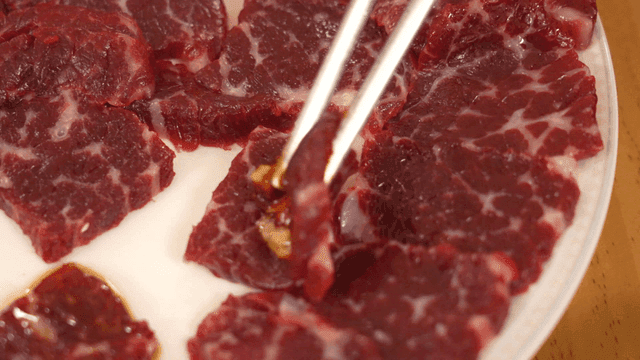 Picking up seasoned Korean beef chunk with chopsticks