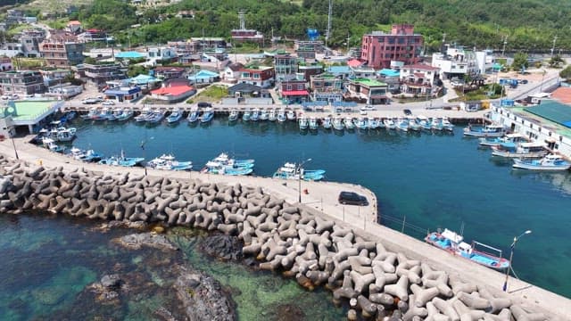 Coastal village with fishing boats and breakwaters