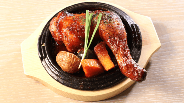 Wood-fired grilled chicken legs on griddle