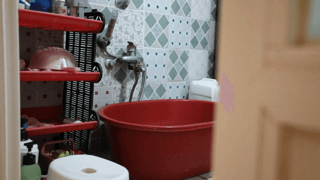 Bathroom with a red basin and shelves