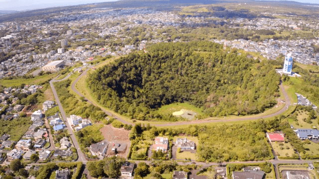 도시 속 숲이 우거진 분화구의 항공 뷰