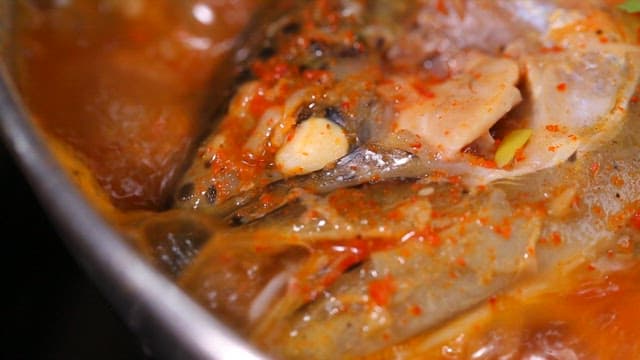 Spicy fish stew with trout boiling in a pot