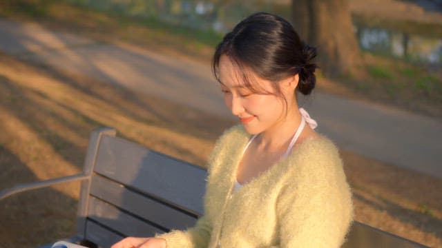 Woman reading a book on a park bench