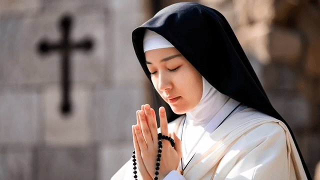 Nun praying with rosary