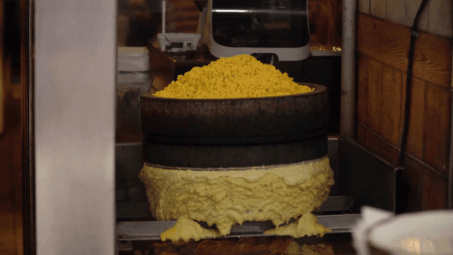 Mung beans being ground on traditional millstone