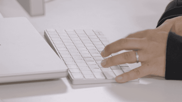 Hands typing on white keyboard