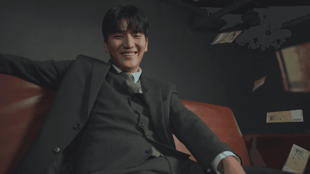 소파에 앉아 돈을 뿌리는 남성