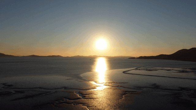 Sunset over calm sea in distance