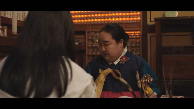 여성에게 부적을 건네는 무당