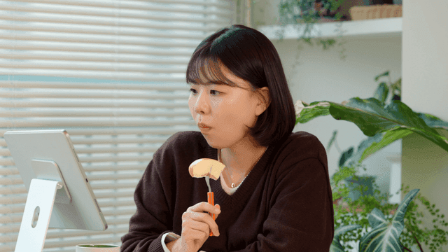 Young woman studying while eating apple