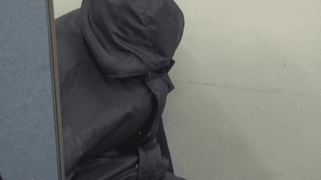 Person sitting indoors wearing a jacket