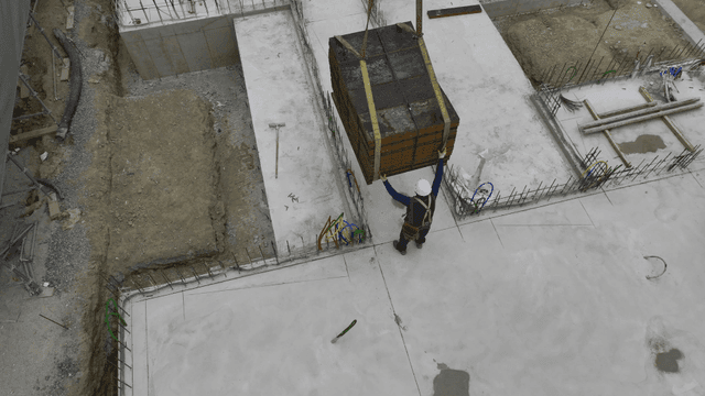 Construction worker guiding a load