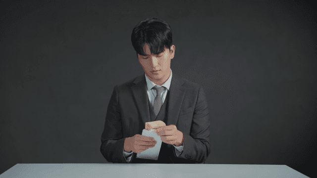 책상에서 돈을 세는 정장 입은 남자