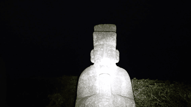 Stone statues in a dark outdoor setting