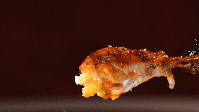 Whole chicken leg lifted by hand