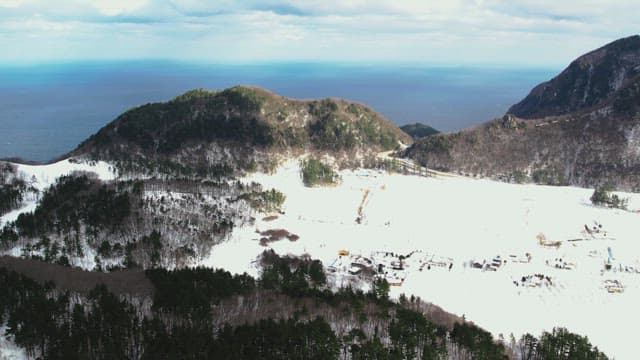 Snow-Covered Mountain Village with a View of the Sea