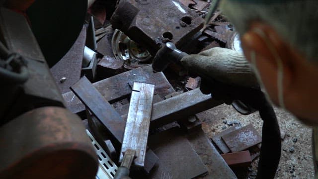 Worker welding metal pieces in a workshop