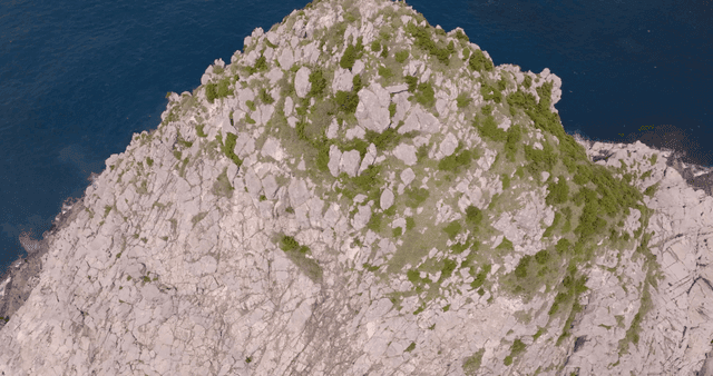 바다 파도에 둘러싸인 바위섬