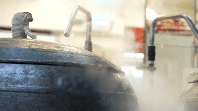 Steam rising from large cauldron