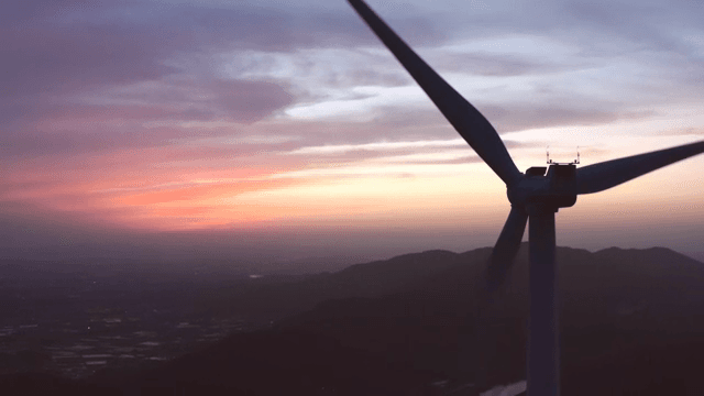 핑크빛으로 물들은 하늘 아래 산악 지역의 풍력 터빈