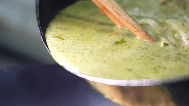 Green jjamppong with being stirred in a pan