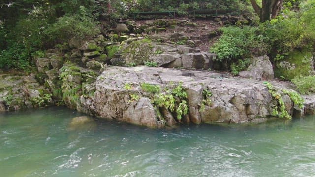 Tranquil river flowing by rocky terrain