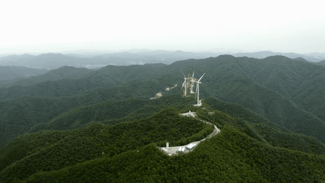 울창한 산악 지역 위의 풍력 터빈