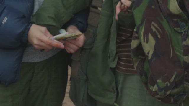 야외에서 돈을 주고받는 두 사람