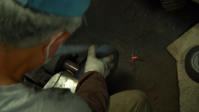 Worker sharpening a knife in a workshop