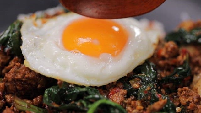 Fried egg on top of spinach rice with minced meat