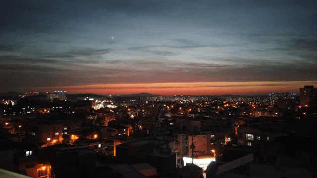 도시의 불빛이 빛나는 황혼의 스카이라인