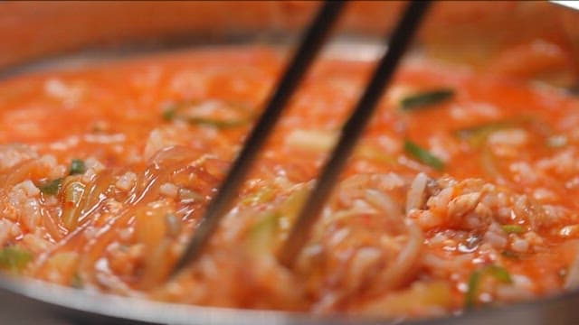 당면과 채소, 밥이 들어간 매콤한 어죽을 젓가락으로 뒤적거리기