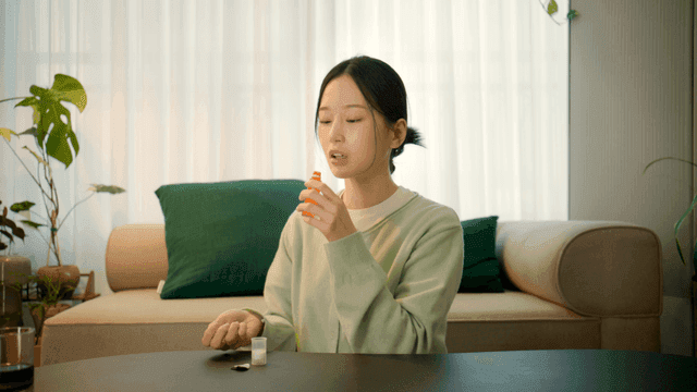 Woman takes vitamin supplements at home.