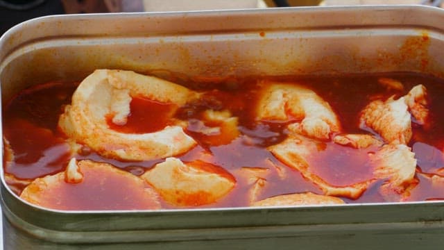 휴대용 금속 냄비에서 요리되는 순두부 찌개에 라면 사리 넣기