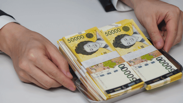 한국 원화 지폐가 놓인 트레이를 건내 받는 손