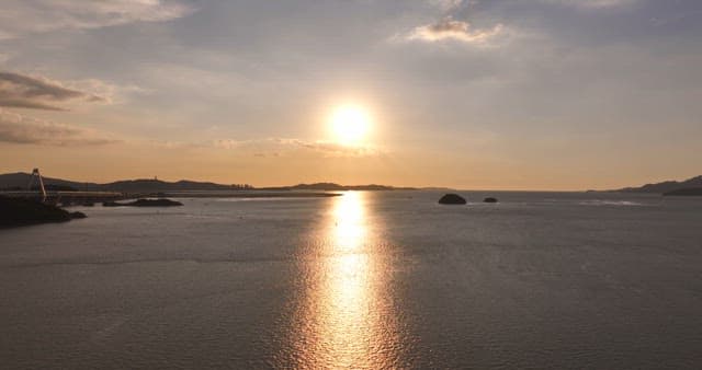 Sunset over a calm sea with a bridge