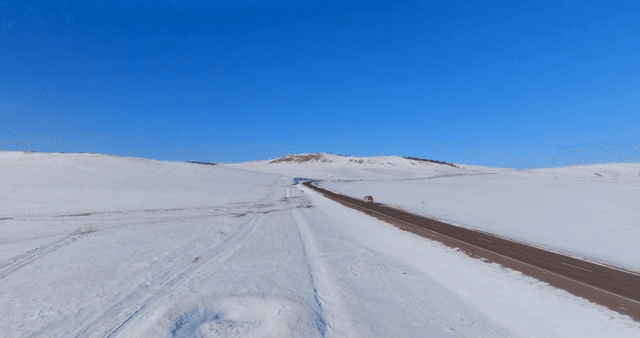 Car driving on a road with a snowy landscape