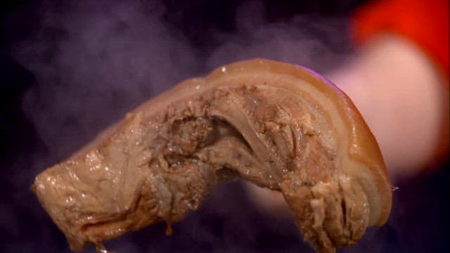 김이 나는 수육을 들어올리는 모습