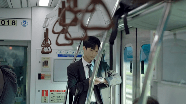 Office worker looking at watch on subway