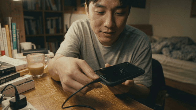 Man charging his phone at desk
