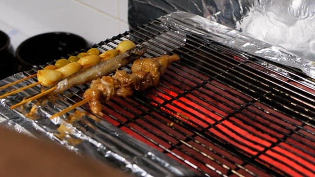 뜨거운 숯불 위에 구워지는 꼬치구이